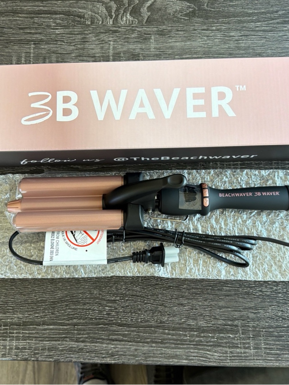 The Beachwaver Co. curling iron box in brown and pink accents